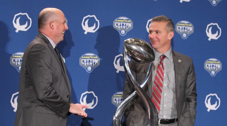 Southern California coach Clay Helton and Ohio State coach Urban Meyer pose for a photo with the Cotton Bowl trophy on Thursday, Dec. 28, 2017, at the Omni Dallas Hotel in Dallas, Texas. David Jablonski/Staff