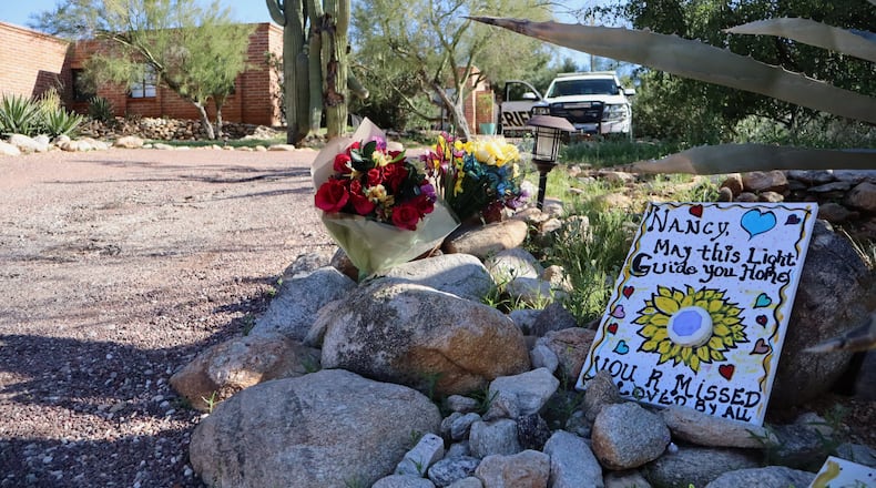 A memorial grows outside the home of Nancy Guthrie, the missing mother of "Today" show host Savannah Guthrie, in Tucson, Ariz., Sunday, Feb. 22, 2026. (AP Photo/Felicia Fonseca)
