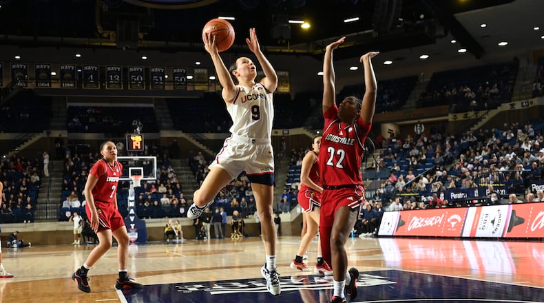 UConn guard Kayleigh Heckel (9) shoots as Louisville guard Tajianna Roberts (22) defends during the first half of a NCAA college basketball game, Tuesday, Nov. 4, 2025, in Annapolis, Md. (AP Photo/Gail Burton)