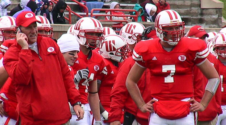 Wittenberg head coach Joe Fincham, left, talks to his staff in the press box on a cell phone during a game against Carnegie-Mellon on Oct. 24 at Edwards-Maurer Field. The team’s normal headsets weren’t working that day. At right is quarterback Aaron Huffman. Staff photo by David Jablonski