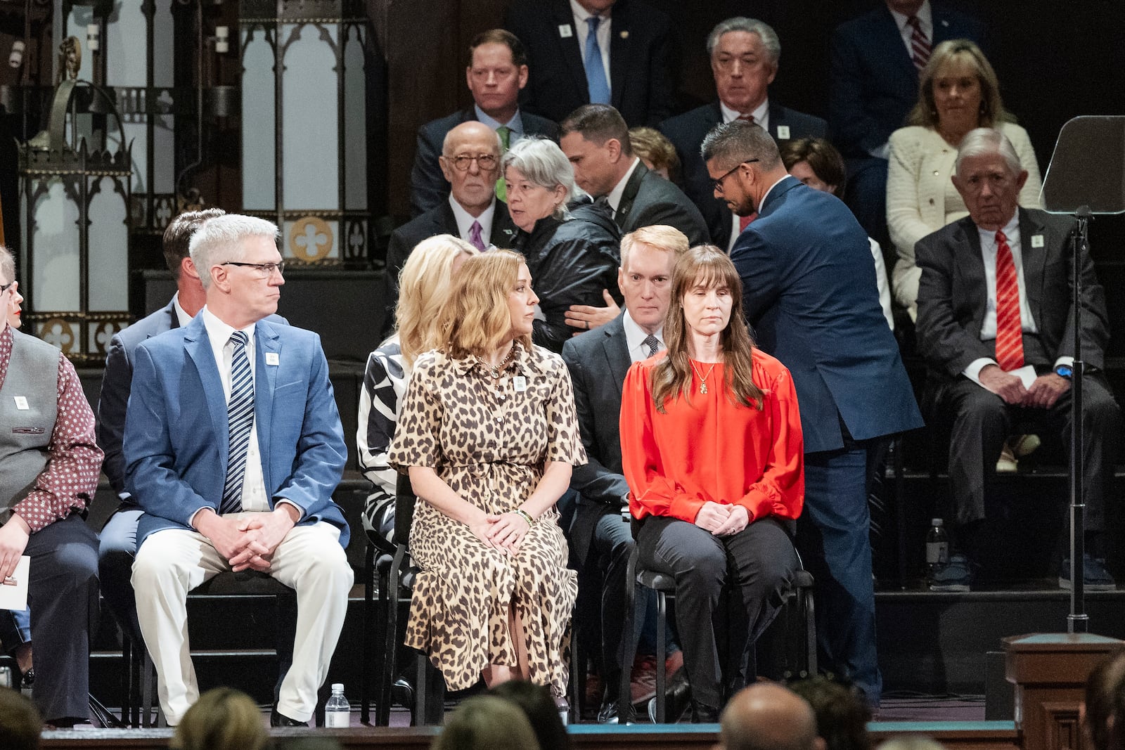 A woman is escorted away after getting onto the stage to speak to U.S. Senator James Lankford during the 30th anniversary memorial service for the victims of the 1995 Oklahoma City bombing, in Oklahoma City, Saturday, April 19, 2025. (AP Photo/Alonzo Adams)