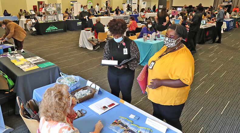 Angeline Chapman, right, and Imani McPheters, both from Ohio Means Jobs, talk to employers during a job fair in Clark County last year. BILL LACKEY/STAFF