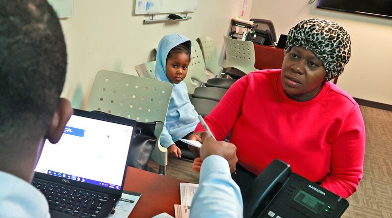 Lormilia Laguerre, an immigrant from Haiti, visits Johnson Salomon, an interpreter at the Rocking Horse Center, for help with immigration paperwork she received Wednesday, May 3, 2023, as her daughter, Snica, waits in the background. BILL LACKEY/STAFF