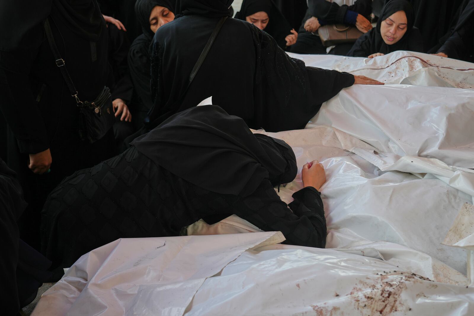 Mourners attend the funeral of their relatives who were killed in an Israeli bombardment, in Deir al-Balah, Gaza Strip, Saturday, July 12, 2025. (AP Photo/Abdel Kareem Hana)