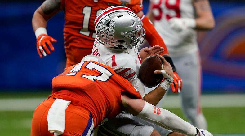 Ohio State quarterback Justin Fields gets hit by Clemson linebacker James Skalski during the first half of the Sugar Bowl NCAA college football game Friday, Jan. 1, 2021, in New Orleans. Skalski was ejected from the game for targeting. (AP Photo/Gerald Herbert)