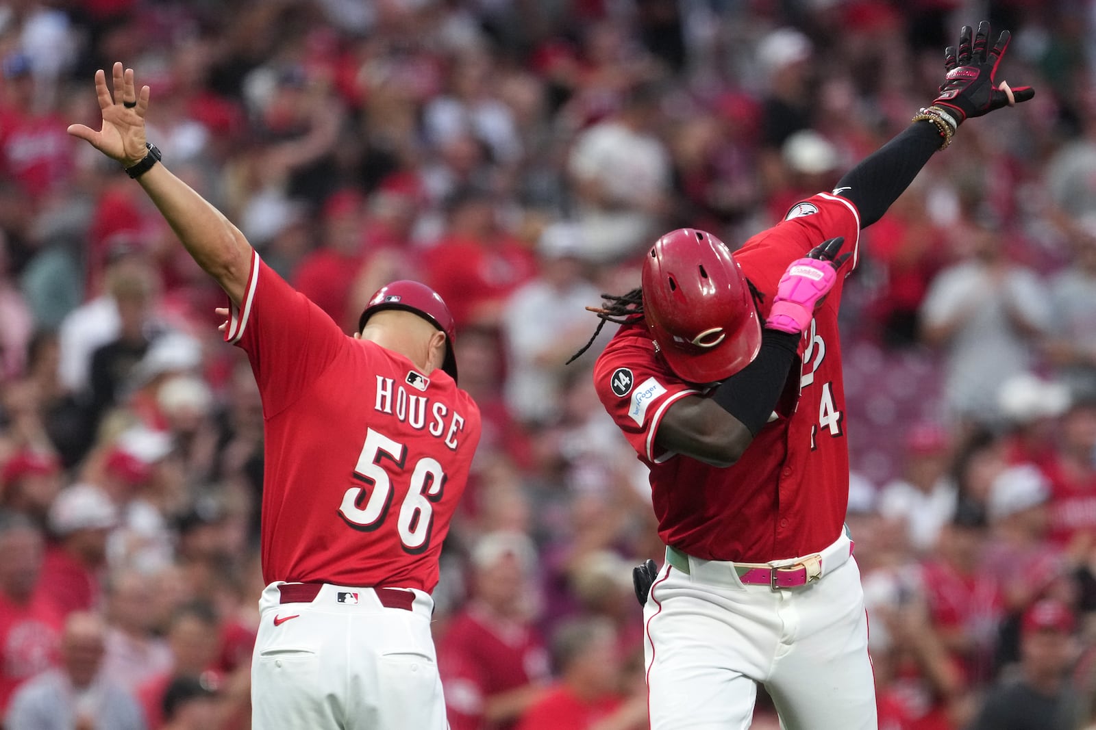 Cincinnati Reds' Elly De La Cruz, far right, celebrates a two-run home run with third base coach J.R. House, left, in the second inning of a baseball game against the Pittsburgh Pirates, Tuesday, Sept. 23, 2025, in Cincinnati. (AP Photo/Kareem Elgazzar)
