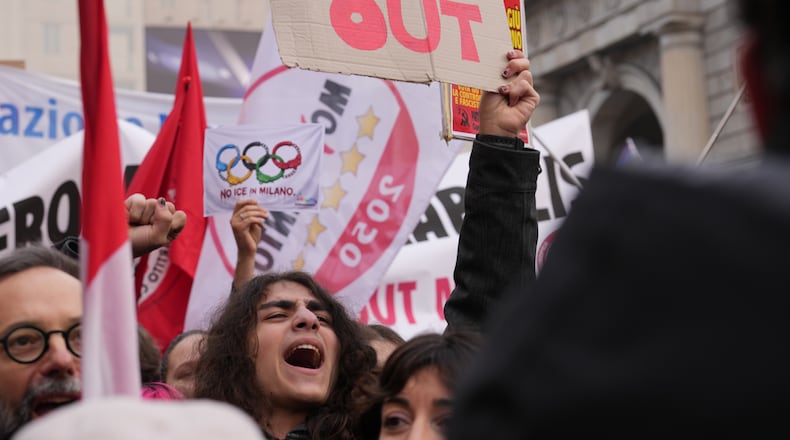 A person holds a sign, during an Anti-ICE demonstration, ahead of the 2026 Winter Olympics, in Milan, Italy, Saturday, Jan. 31, 2026. (AP Photo/Antonio Calanni)