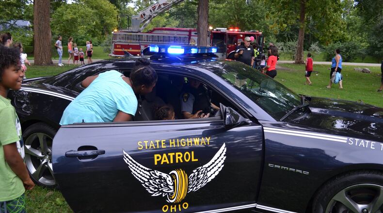 Children take a look inside an Ohio State Patrol vehicle during the National Night Out event last year. The free gathering will take place in Snyder Park this Tuesday. CONTRIBUTED