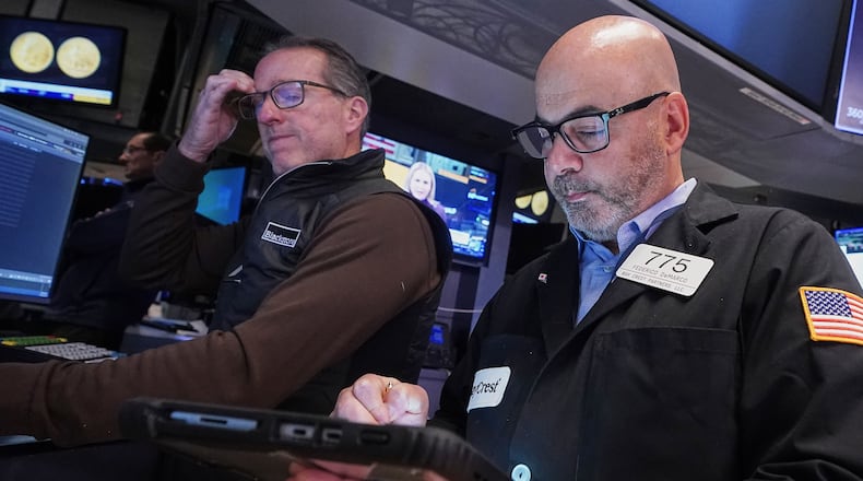 Specialist Glenn Carell, left, and trader Fred Demarco work on the floor of the New York Stock Exchange, Tuesday, Nov. 18, 2025. (AP Photo/Richard Drew)