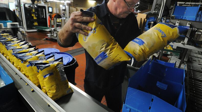 Tim White, a 26 year employee of Mikesell's, packs bags of chips into boxes Thursday Dec. 1, 2022. MARSHALL GORBY\STAFF