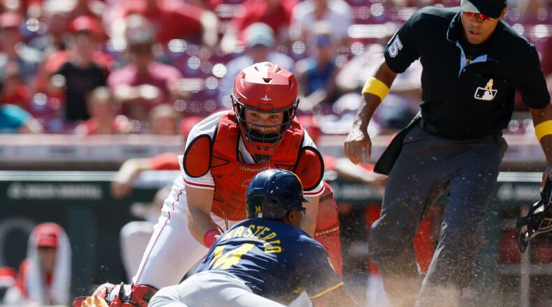Cincinnati Reds catcher Tyler Stephenson, top left, tags out Milwaukee Brewers' Andruw Monasterio, bottom left, during the 10th inning of a baseball game Sunday, Sept. 1, 2024, in Cincinnati. (AP Photo/Jay LaPrete)