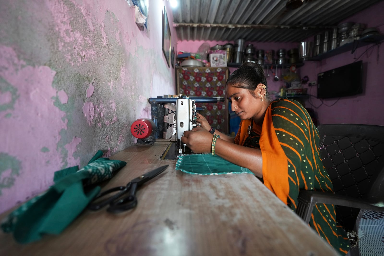 Sapnaben Chunara works on a sewing machine inside her house in Ahmedabad, India, Wednesday, April 2, 2025. (AP Photo/Ajit Solanki)