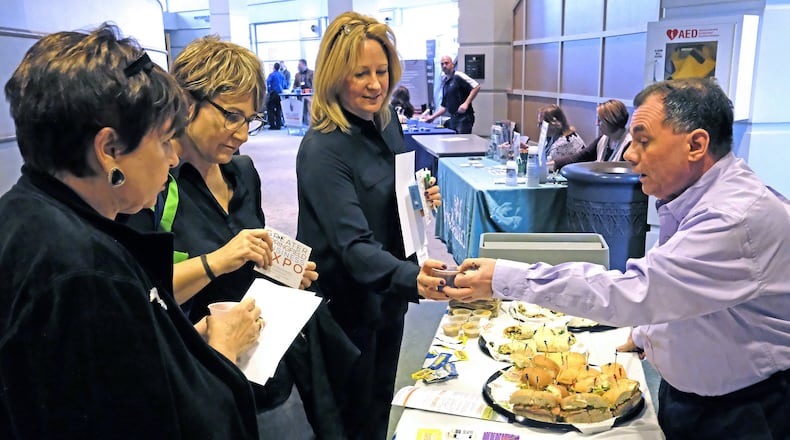 Sue Smedley, left, Lisa Smedley, Center, and Liz Simonton try samples at Tim Poulos’ Tropical Smoothie Cafe booth at the Springfield Business EXPO at the Clark State Performing Arts Center. Bill Lackey/Staff