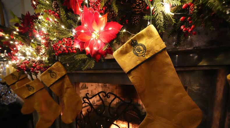Christmas stockings created by members of the King's Foundation Sewing Bee group, which have been made using curtains repurposed from the Sandringham Estate in Norfolk, are hung from the fireplace in the Yellow drawing room at Dumfries House, which is part of The King's Foundation near Cumnock, Ayrshire, Scotland, Tuesday, Nov. 25, 2025. (Andrew Milligan/PA via AP)