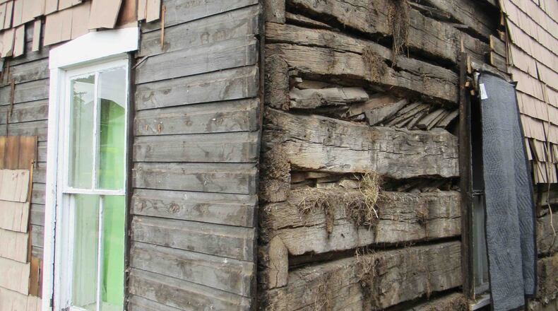 Two centuries of architectural history is revealed. Two layers of siding were removed to reveal the original wall of the cabin which was built in 1810. The ends of the logs visible at the corner show a “V Notch” style of notching. Photo by David McWhorter.