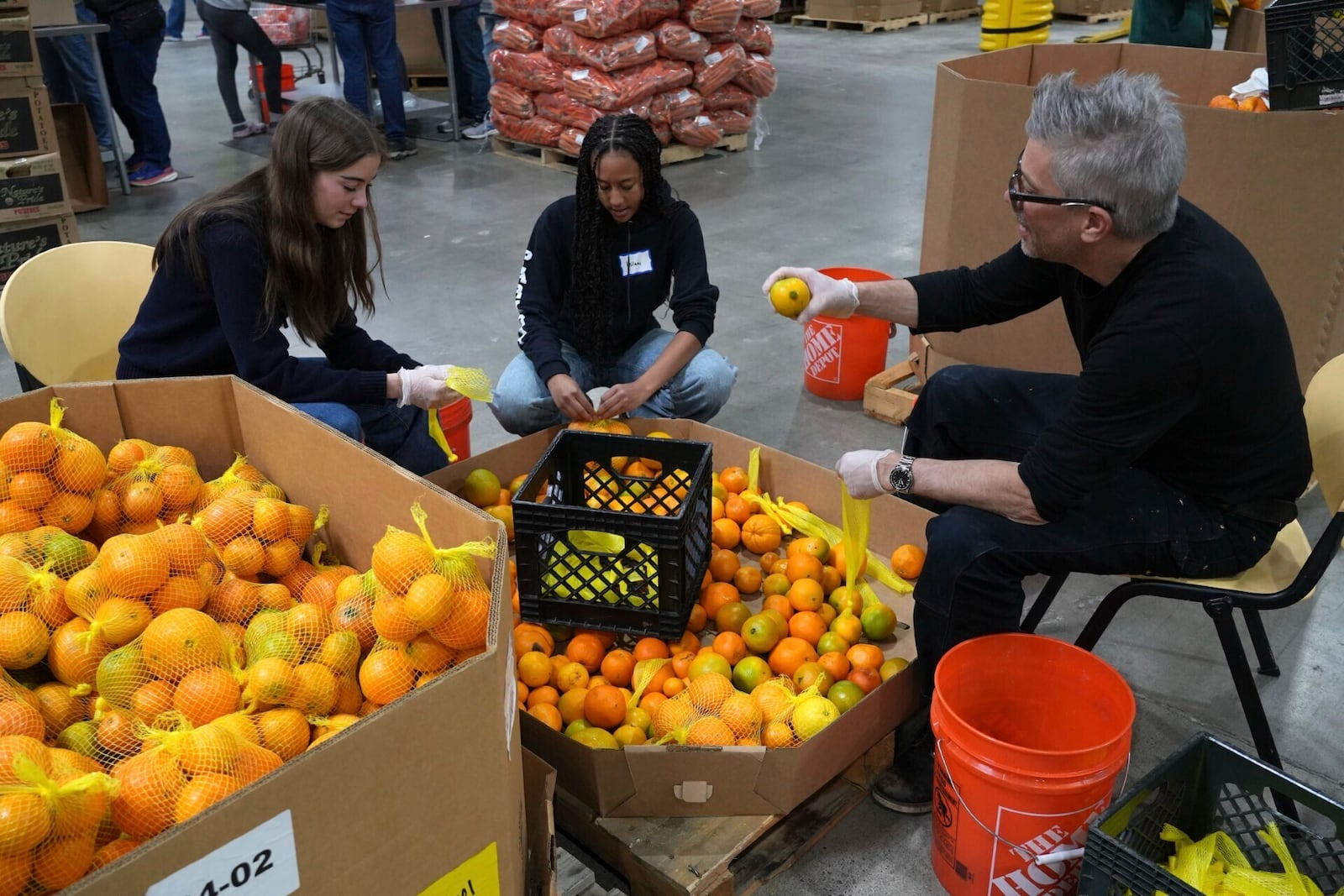 Volunteers pack produce at the Alameda County Community Food Bank in Alameda, Calif., on Friday, April 25, 2025. (AP Photo/Terry Chea)