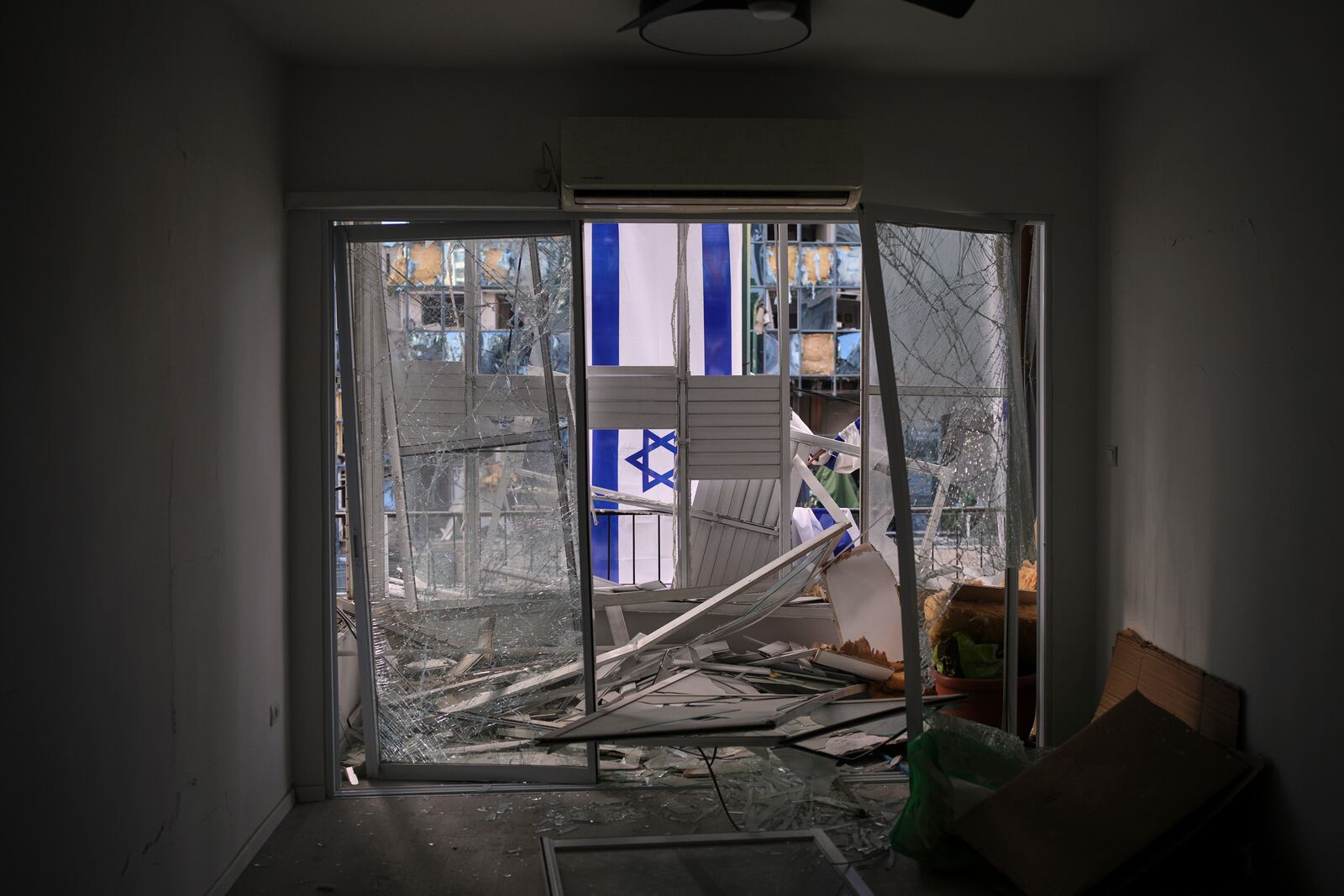 An Israeli flag is hung outside a damaged apartment two days after it was struck by a missile launched from Iran, in Ramat Gan, Israel, on Saturday, June 21, 2025. (AP Photo/Ohad Zwigenberg)