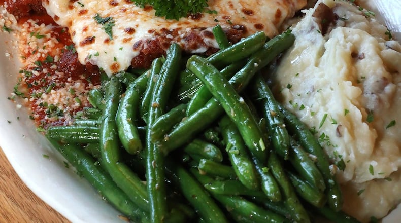 Chicken Parmesan with green bean and garlic smashed potatoes. BILL LACKEY/STAFF