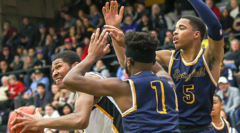 Centerville High School’s Mo Njie is guarded by Springfield’s Larry Stephens and Raheim Moss during their game at Centerville High School on Friday, Dec. 14. The Wildcats won 64-60. CONTRIBUTED PHOTO BY MICHAEL COOPER