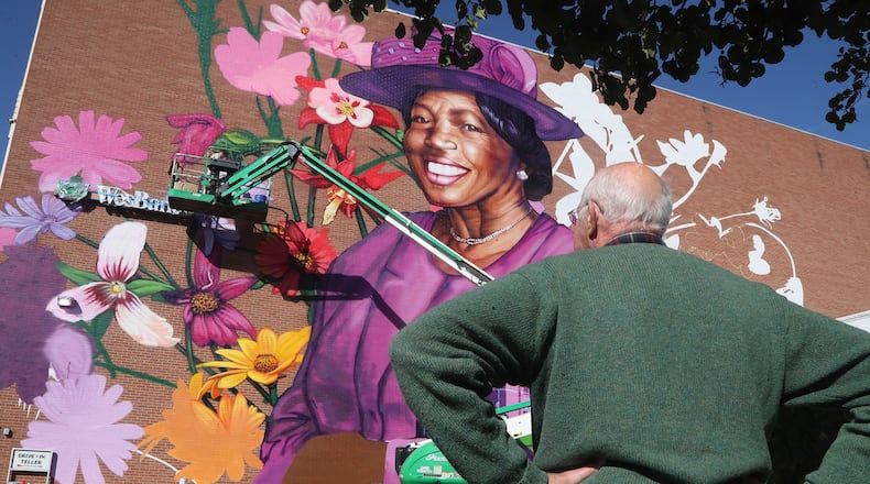 People gather around the mural of Springfield civil rights advocate Hattie Moseley during a dedication ceremony Tuesday, Oct. 11, 2022. BILL LACKEY/STAFF