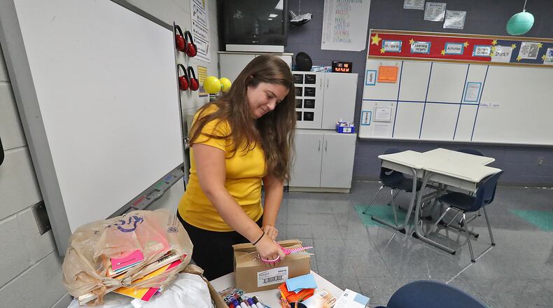Fulton fifth-grade teacher Lindsay Henderson opens boxes of school supplies in her classroom last year as she got ready for school to start back. FILE/BILL LACKEY/STAFF