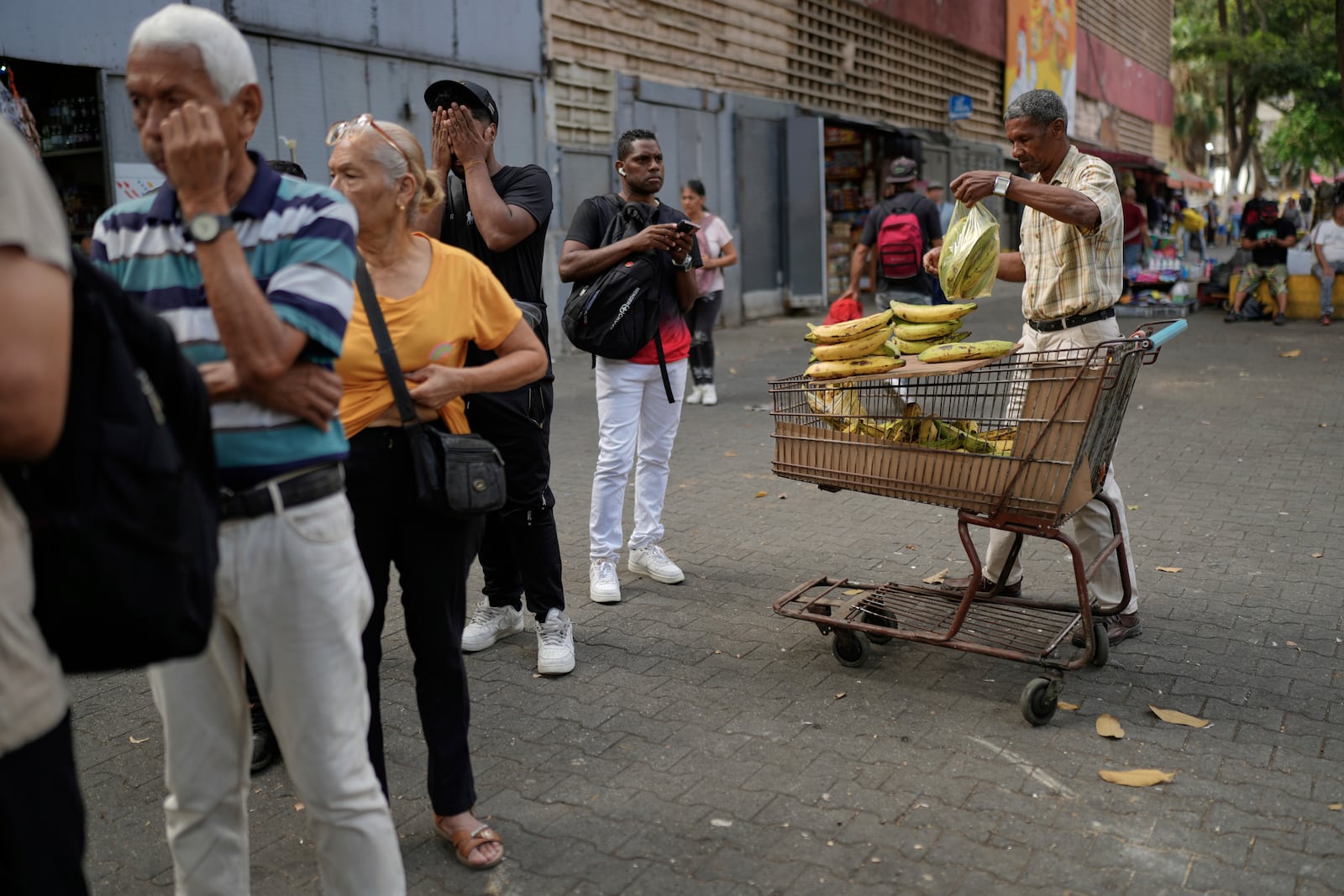 Arnold Guerrero sells plantains in the street in Caracas, Venezuela, Friday, April 11, 2025. (AP Photo/Ariana Cubillos)