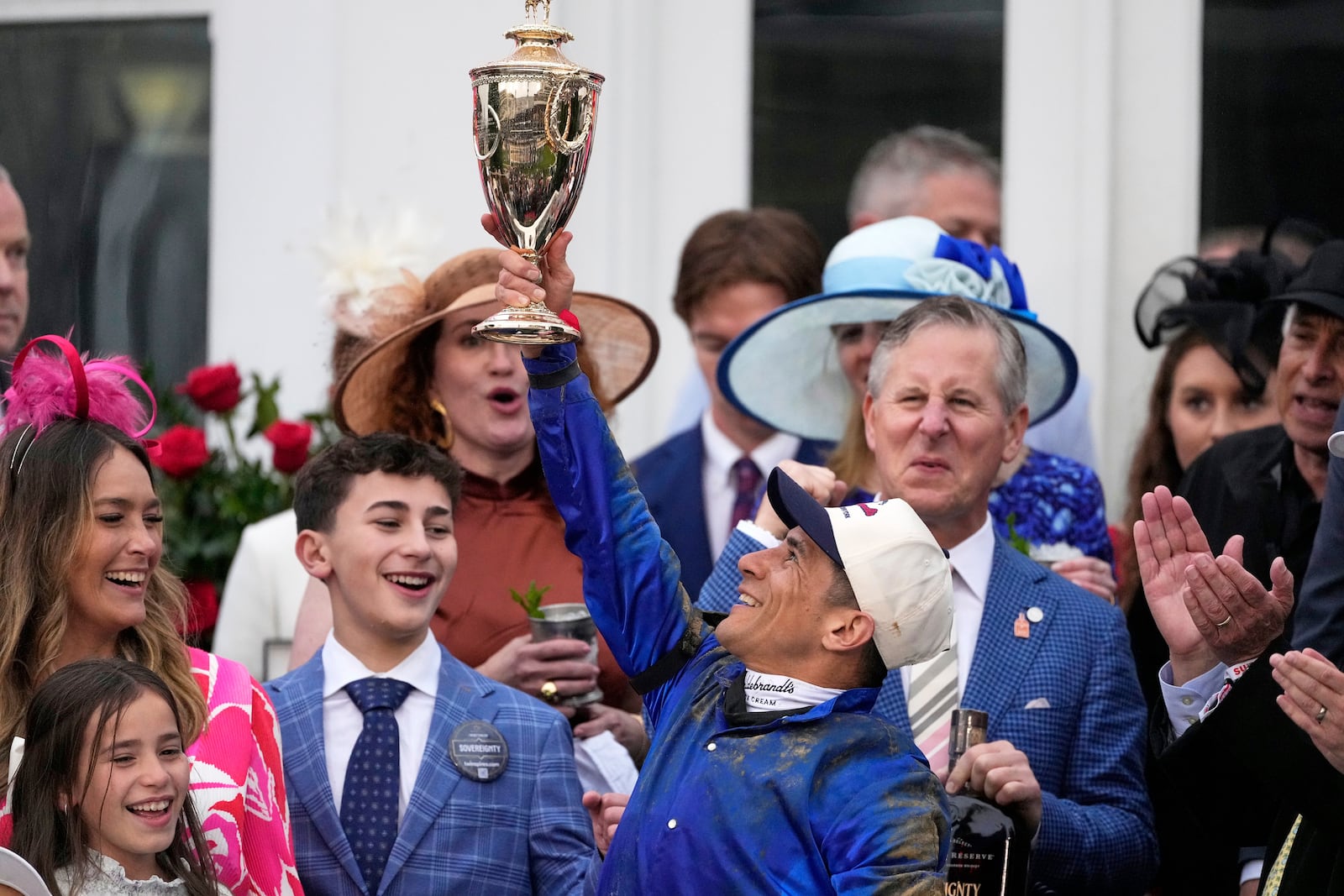 Junior Alvarado holds the trophy as he celebrates after riding Sovereignty to victory in the 151st running of the Kentucky Derby horse race at Churchill Downs Saturday, May 3, 2025, in Louisville, Ky. (AP Photo/Brynn Anderson)