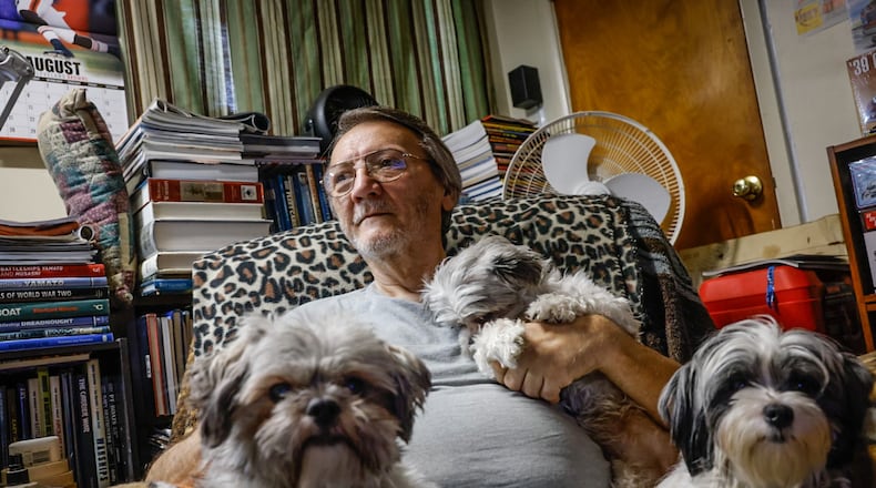 Joseph F. Applegate sits in his favorite chair, in his favorite room with his Shih tzus in his north Dayton home.  Applegate made the mortgage payments every month, but his deceased partner's name was on the deed, which has caused a dispute with Medicaid. JIM NOELKER/STAFF
