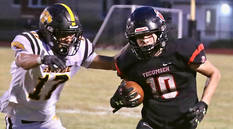 Tecumseh's Braden Berner tries to avoid a tackle by Shawnee's Cameron Brucker. BILL LACKEY/STAFF