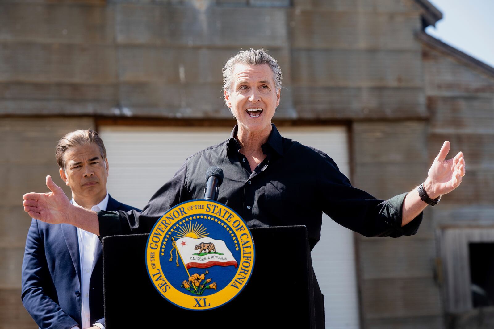 California Gov. Gavin Newsom discusses President Donald Trump's tariffs, as California Attorney General Rob Bonta, left, listens, during a press conference on Wednesday, April 16, 2025, at an almond farm in Ceres, Calif. (AP Photo/Noah Berger)