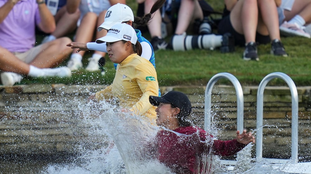 FILE -Mao Saigo, of Japan, in yellow, jumps into the water after winning the Chevron Championship LPGA golf tournament April 27, 2025, in The Woodlands, Texas. (AP Photo/Eric Gay, File)