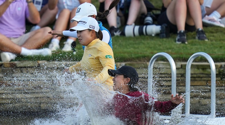 FILE -Mao Saigo, of Japan, in yellow, jumps into the water after winning the Chevron Championship LPGA golf tournament April 27, 2025, in The Woodlands, Texas. (AP Photo/Eric Gay, File)