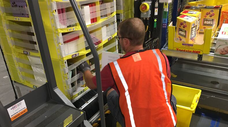 A worker loads products at the Amazon facility in Etna, Ohio. KARA DRISCOLL/STAFF