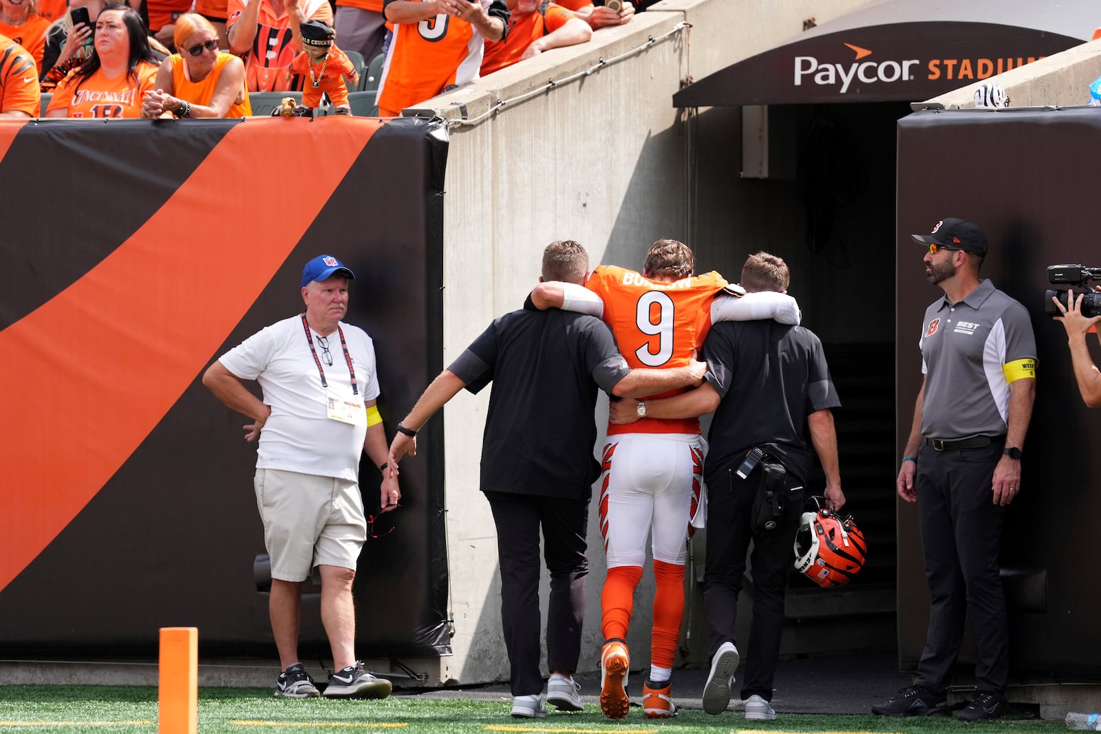 Cincinnati Bengals quarterback Joe Burrow, center, is helped off the field after suffering an injury during the second quarter of an NFL football game against the Jacksonville Jaguars, Sunday, Sept. 14, 2025, in Cincinnati. (AP Photo/Kareem Elgazzar)