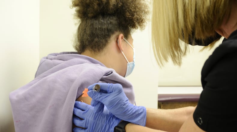 Brooklyn Brundidge, 12, a seventh-grader at Garfield Middle School in Hamilton, receives a vaccine shot on Wednesday, Sept. 14, 2022, from Public Health Nurse Betsy Waldeck at the Butler County General Health District clinic in downtown Hamilton. MICHAEL D. PITMAN/STAFF