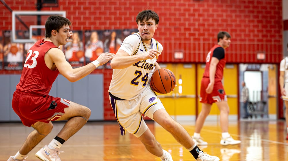 Emmanuel Christian Academy senior Nate Hudson drives past Twin Valley South junior Lucas Barlow boys basketball team beat Twin Valley South in a Division VI district semifinal game on Monday, March 2, 2026 at Troy High School. The Lions won 73-50. MICHAEL COOPER / STAFF