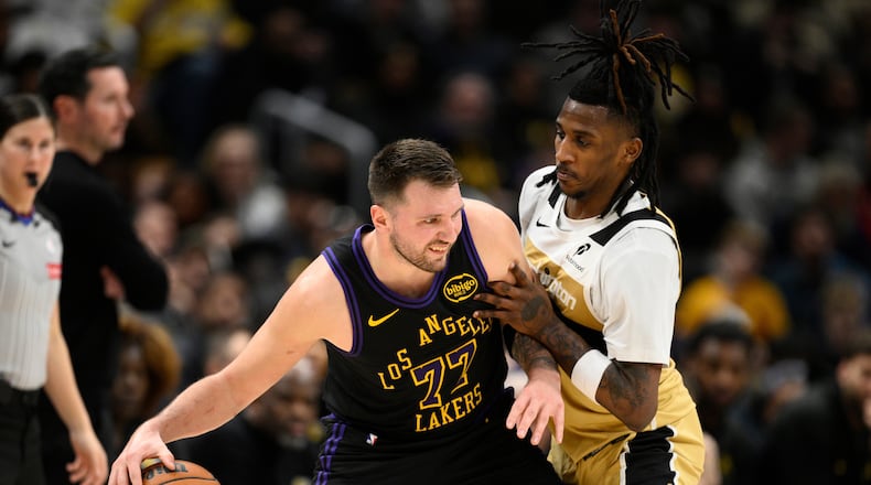 Los Angeles Lakers guard Luka Doncic (77) dribbles against Washington Wizards guard Jamir Watkins, right, during the first half of an NBA basketball game, Friday, Jan. 30, 2026, in Washington. (AP Photo/Nick Wass)