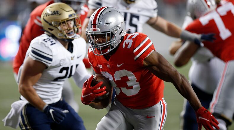 Ohio State running back Master Teague, front, breaks through the line of scrimmage to score a touchdown against Akron during the second half of an NCAA college football game Saturday, Sept. 25, 2021, in Columbus, Ohio. (AP Photo/Jay LaPrete)