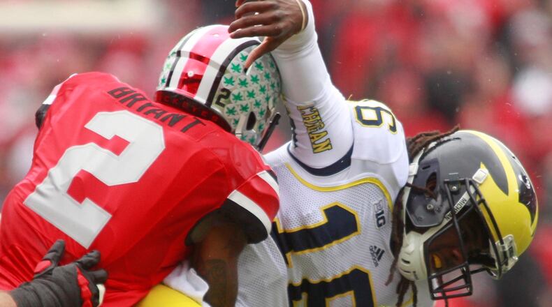 In this Nov. 24, 2012 photo, Denard Robinson (16) of Michigan is tackled by Christian Bryant (2) of Ohio State. Lest we forget: the Ohio State Buckeyes beat Michigan 26-21 that day to finish an undefeated 12-0 regular season. Staff file photo by Barbara J. Perenic