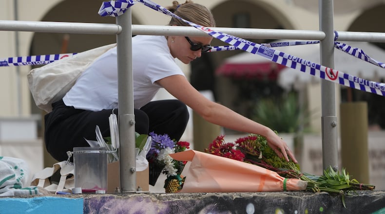 Shenna McClean lays flowers at a memorial at Sydney's Bondi Beach, Monday, Dec. 15, 2025, a day after a shooting. (AP Photo/Mark Baker)