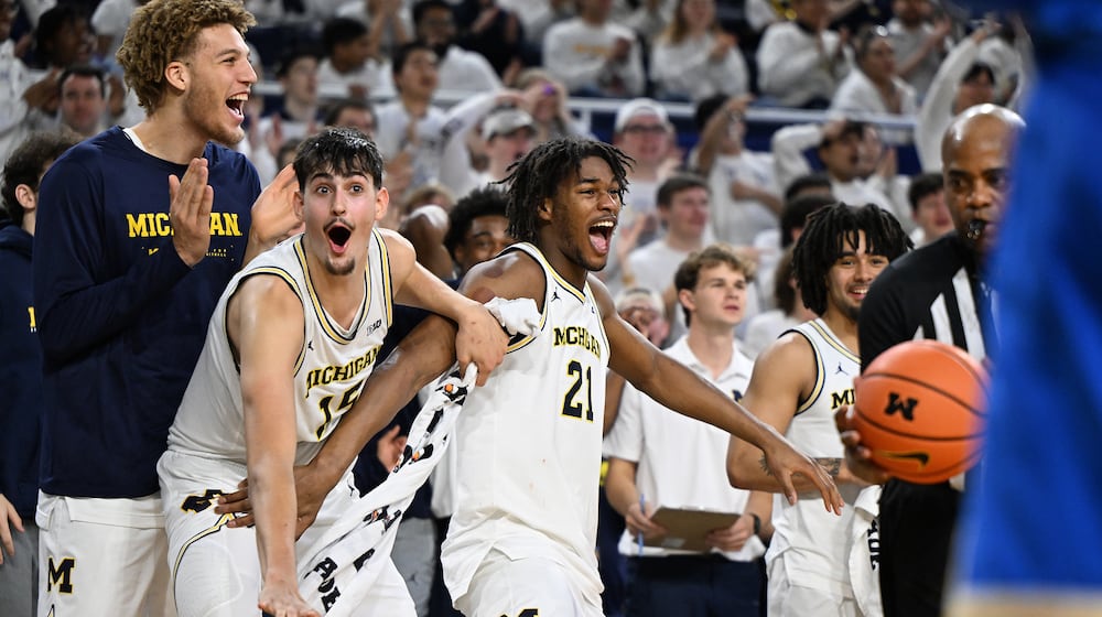 Michigan players, from left, Malick Kordel, Aday Mara, Morez Johnson Jr. and Elliot Cadeau celebrate on the bench late in the second half of a win over UCLA in an NCAA college basketball game in Ann Arbor, Mich., Saturday, Feb. 14, 2026. (AP Photo/Lon Horwedel)