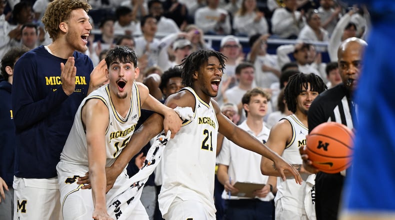 Michigan players, from left, Malick Kordel, Aday Mara, Morez Johnson Jr. and Elliot Cadeau celebrate on the bench late in the second half of a win over UCLA in an NCAA college basketball game in Ann Arbor, Mich., Saturday, Feb. 14, 2026. (AP Photo/Lon Horwedel)
