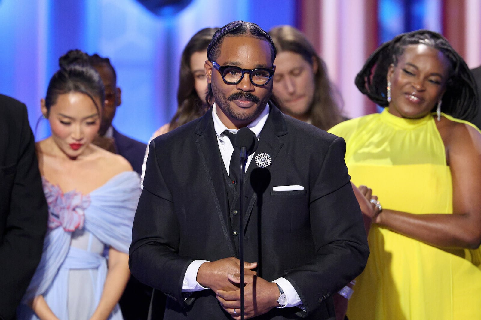 This image released by CBS Broadcasting shows Ryan Coogler, center, accepting the award for cinematic and box office achievement for "Sinners" during the 83rd Golden Globes on Sunday, Jan. 11, 2026, at the Beverly Hilton in Beverly Hills, Calif. (Kevork Djansezian/CBS Broadcasting via AP)