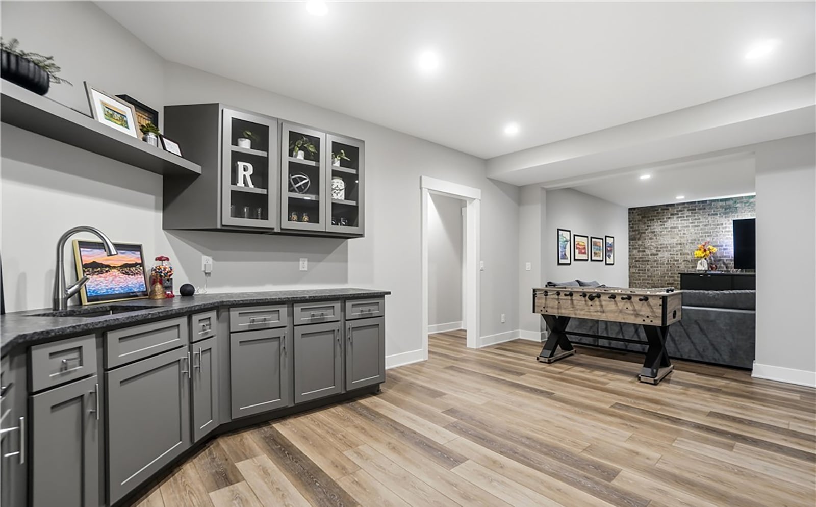 The finished basement has two bedrooms and one and half baths and a recreation room with a kitchenette and brick accent wall. CONTRIBUTED