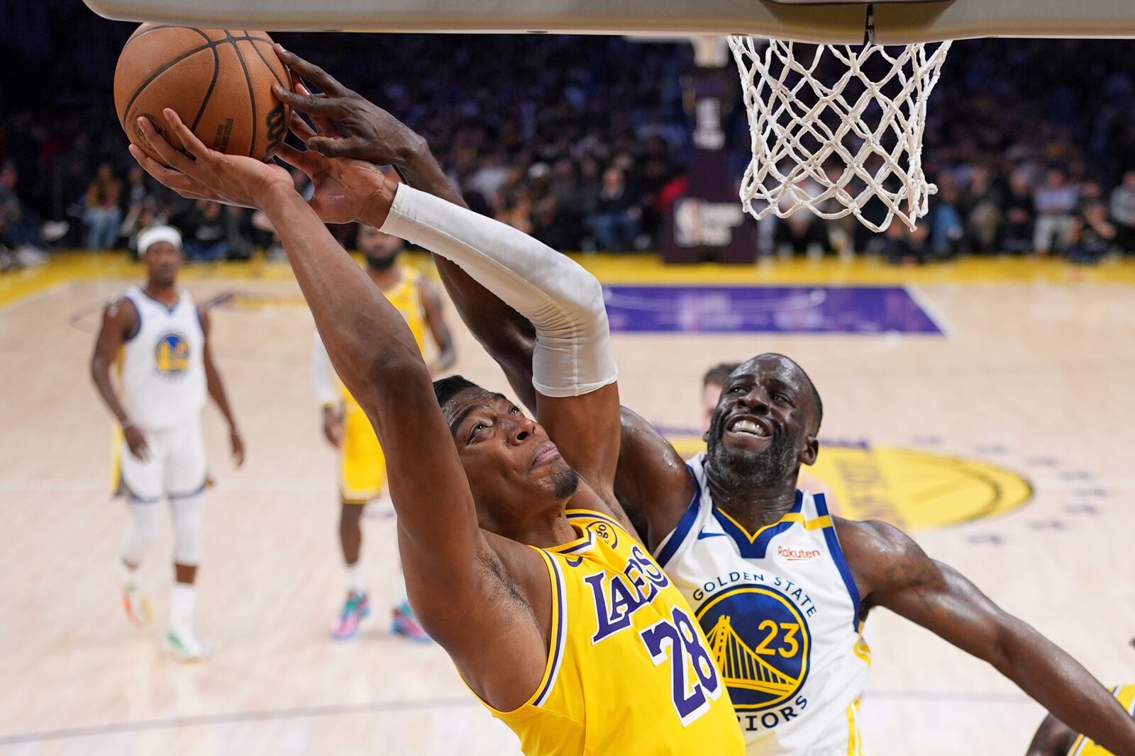 Los Angeles Lakers forward Rui Hachimura, left, shoots as Golden State Warriors forward Draymond Green defends during the first half of an NBA basketball game Thursday, April 3, 2025, in Los Angeles. (AP Photo/Mark J. Terrill)