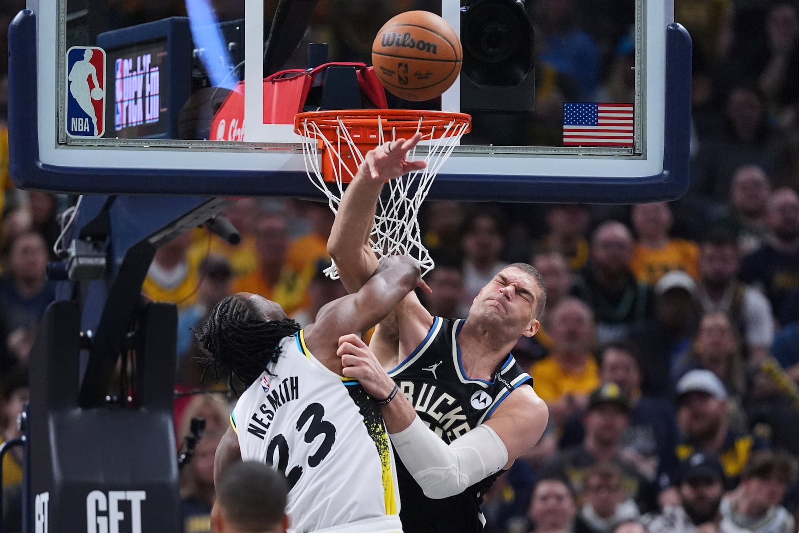 Milwaukee Bucks center Brook Lopez (11) fouls Indiana Pacers forward Aaron Nesmith (23) as he shoots during the first half of a first-round NBA basketball playoff game in Indianapolis, Tuesday, April 22, 2025. (AP Photo/Michael Conroy)