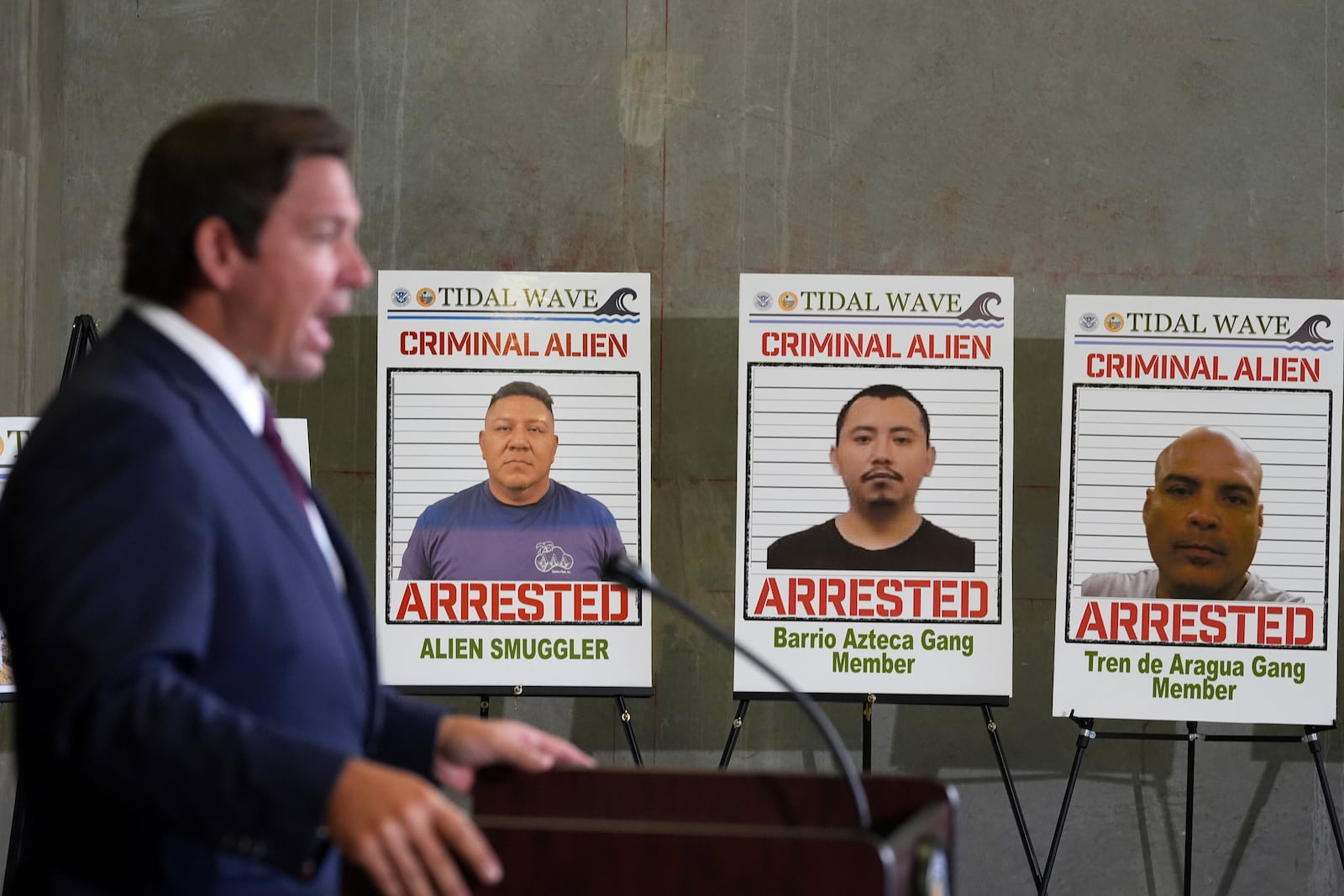 Posters of alleged criminals who officials said were arrested in a recent immigration enforcement operation are displayed as Gov. Ron DeSantis speaks during a press conference at the South Florida office of U.S. Immigration and Customs Enforcement and Enforcement and Removal Operations, Thursday, May 1, 2025, in Miramar, Fla. (AP Photo/Rebecca Blackwell)