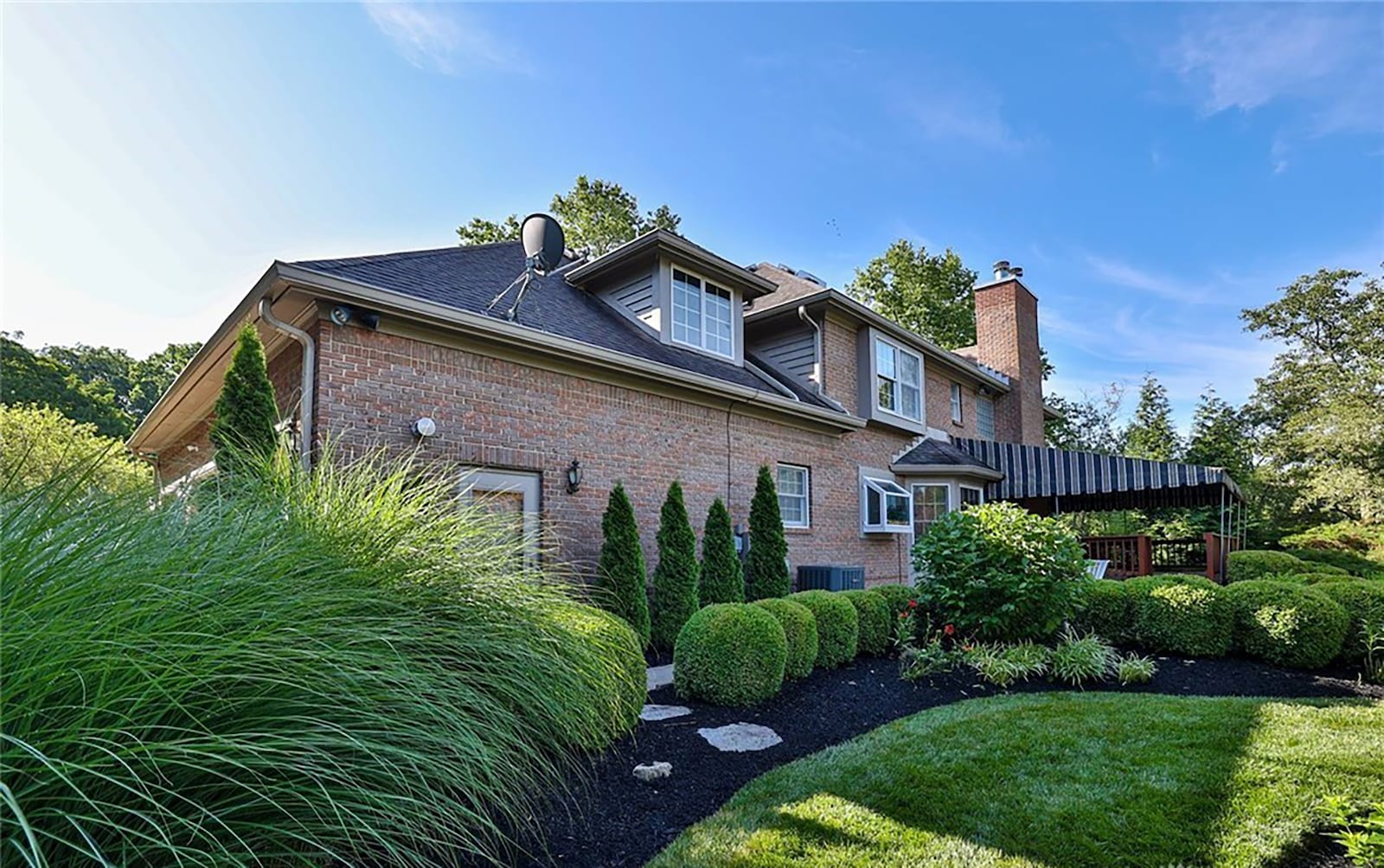 The rear of the home has a wood deck covered by an awning, brick paver patio and heavy landscaping. CONTRIBUTED