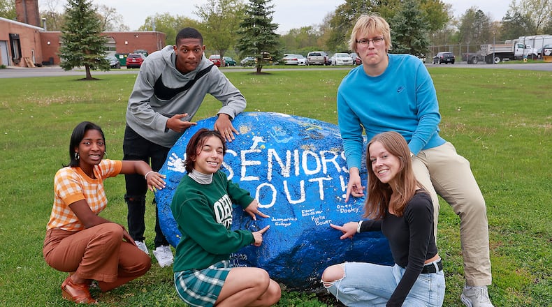 Springfield High School seniors with the Spirit Rock in front of the school Thursday, May 4, 2023. The seniors are, clockwise from left, Nadjah Franklin-Grant, Jimmy Gamblin, Owen Dooley, Karlie Bowen and Jasmonica Gallegos. Fifteen years ago, the first students began classes in the new, combined Springfield High School.  BILL LACKEY/STAFF