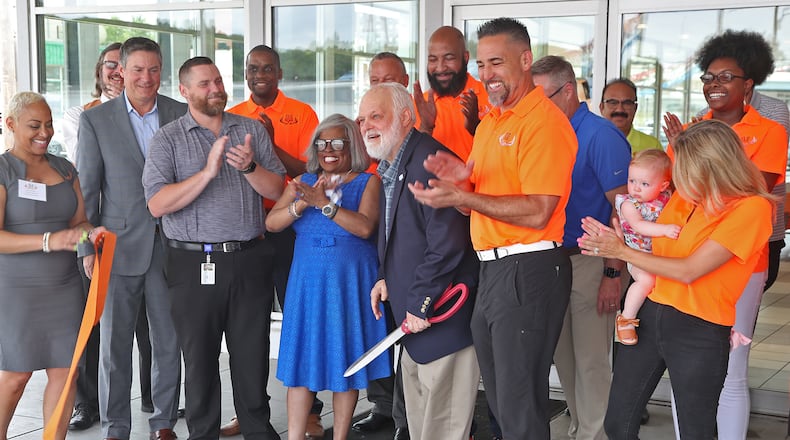 Springfield city officials and SVG Motors employees applaud as Mayor Warren Copeland cuts a ribbon and welcomes Steve VanGorder and the SVG family of dealerships to the city Thursday, June 16, 2022. SVG Motors recently purchased the Springfield Buick and GMC dealership on Columbia Avenue. BILL LACKEY/STAFF